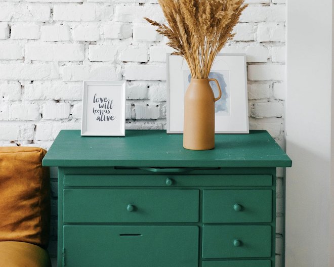 Green dresser, arranged stylishly against a white brick wall